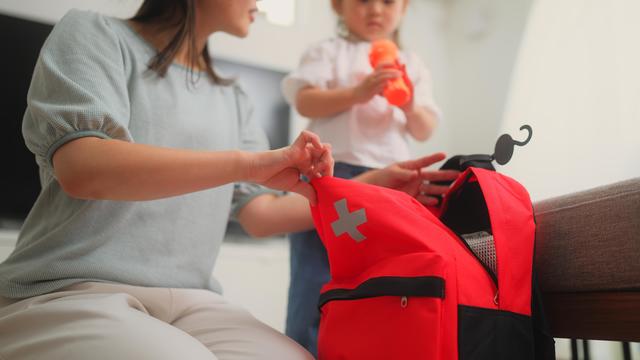 Woman preparing emergency bag at home 