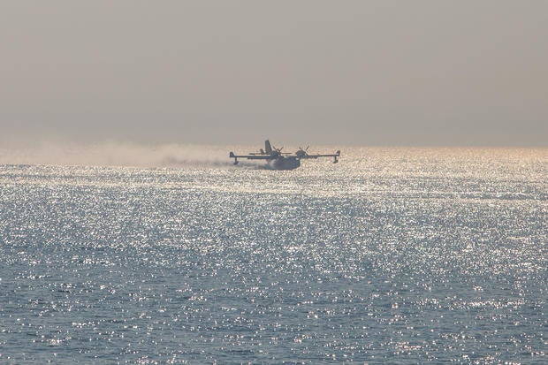 An airtanker gets water from the ocean to fight the Palisades Fire, Jan. 9, 2025. 
