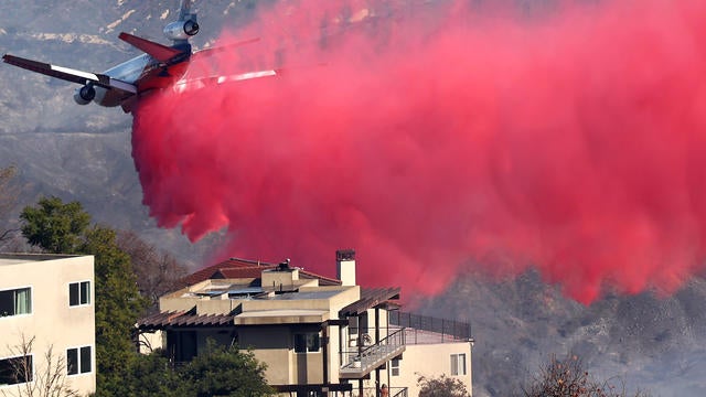 Firefighting aircraft drops pink flame retardant over a neighborhood in Los Angeles 