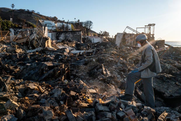 Patrick O'Neal sifts through his home after it was destroyed by the Palisades Fire on Jan. 13, 2025, in Malibu, California. 